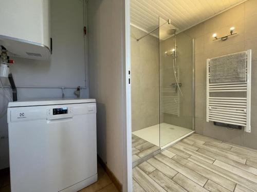 a bathroom with a shower and a washing machine at Chez bourdet-pelou in Arette