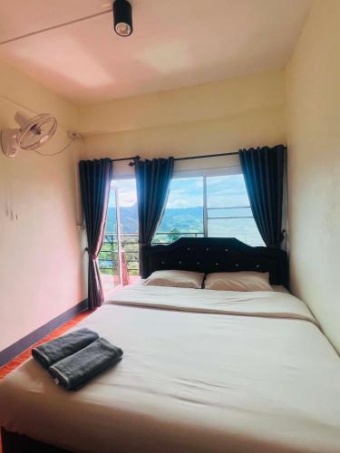 a large bed in a room with a window at สบายดีโฮมสเตย์ภูลังกา in Ban Sakoen