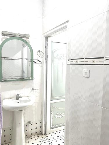 a white bathroom with a sink and a shower at O Ansah Plaza Lodge in Kumasi