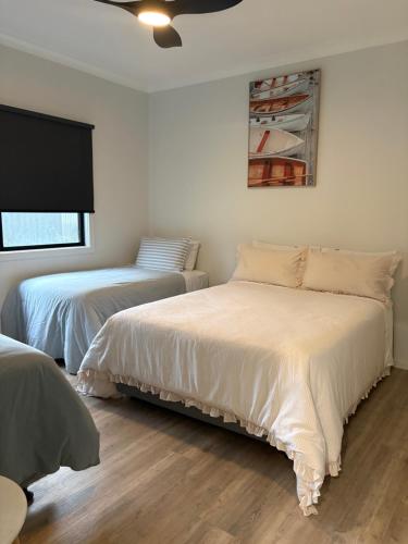 a bedroom with two beds and a tv on the wall at The Bloom in Seaspray