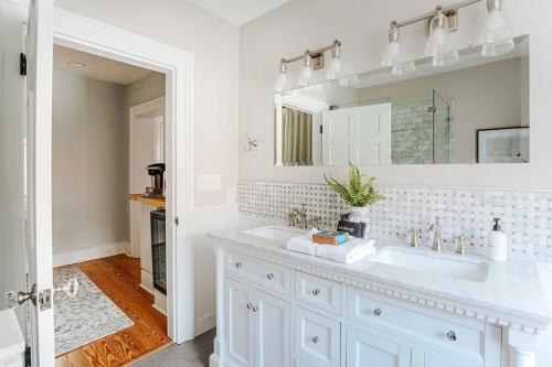 a white bathroom with a sink and a mirror at Magnolia Suite in Staunton