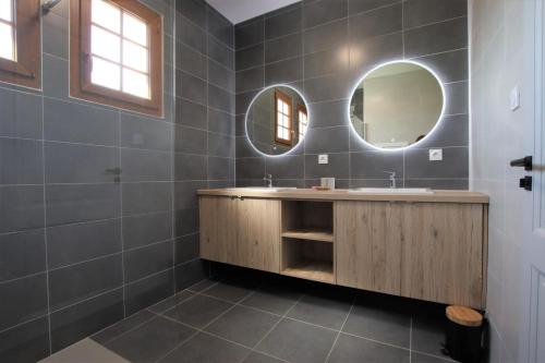 a bathroom with a sink and two mirrors at Arlotia in Ascarat