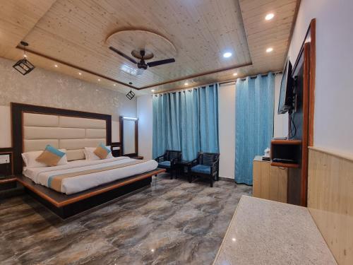 a bedroom with a bed and a flat screen tv at Hotel Biaspushp Dalhousie in Banikhet