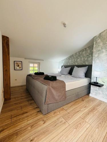 a bedroom with a large bed and a wooden floor at Landhaus Ankerplatz im Grünen, strandnah , fernab vom mainstream , ideal für Familien in Gorow