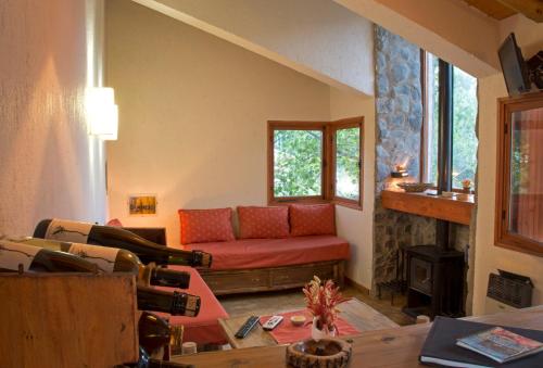 a living room with a red couch and a fireplace at Las Espuelas Casas de Montaña in Potrerillos