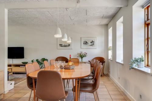 a dining room with a wooden table and chairs at Skjoldbjerg Garnihotel in Vorbasse