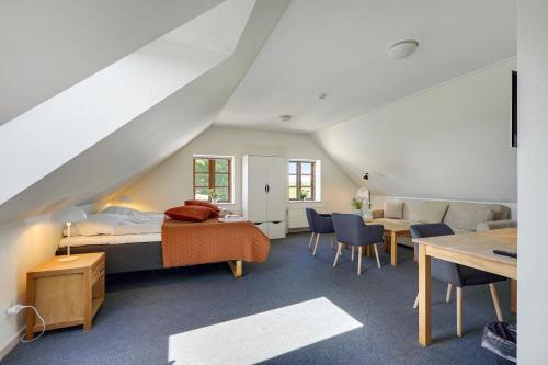 a bedroom with a bed and a couch and a table at Skjoldbjerg Garnihotel in Vorbasse