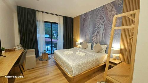 a bedroom with a bed and a large window at Beas Place Klong Dao in Ko Lanta