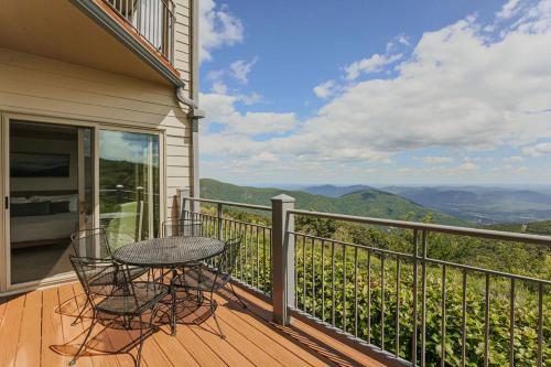 a patio with a table and chairs on a balcony at Panoramic Peak in Mount Torry Furnace
