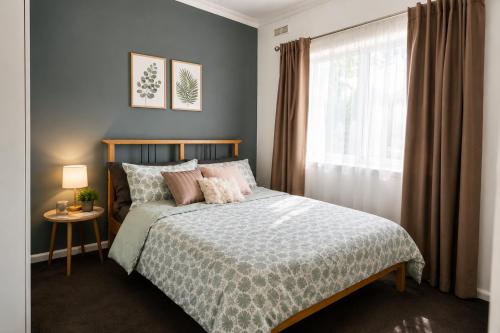 a bedroom with a bed and a window at White House Bendigo Garden Retreat in Epsom