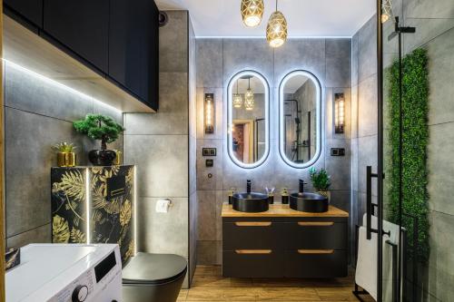 a bathroom with two sinks and two mirrors at Golden Eagle Luxury Apartment - Granary Island- Gdańsk Old Town in Gdańsk