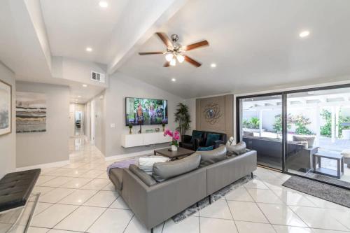 a living room with a couch and a ceiling fan at Disneyland Dream Villa 5 BR 3 BA Arcade Games in Anaheim