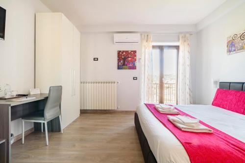 a bedroom with a desk and a bed with a red blanket at 85Centro in Potenza
