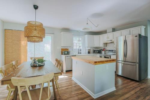 a kitchen with a table and a stainless steel refrigerator at Stuart Cottage in Staunton