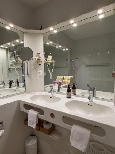 a bathroom with two sinks and a large mirror at Holiday on the Lake Lugano in Bissone