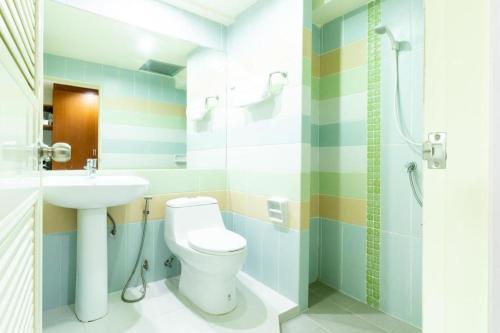 a bathroom with a toilet and a sink at Prosperous in Hat Yai