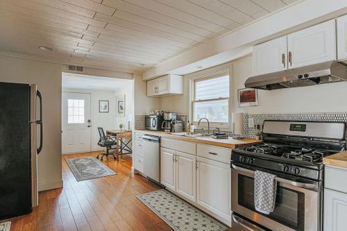 a kitchen with white cabinets and a stove top oven at The Hunker Down in Staunton