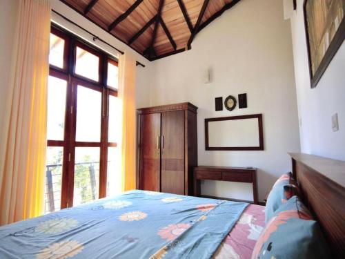 a bedroom with a bed and a large window at Green villa in Galle