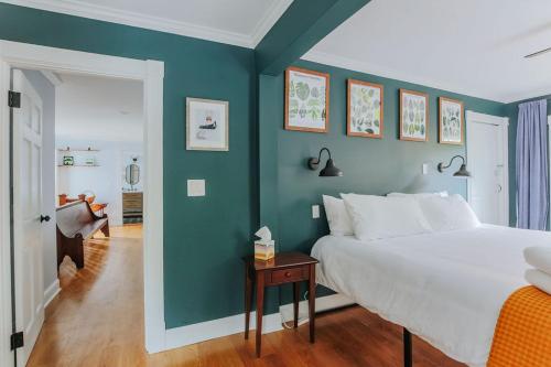 a bedroom with a white bed and a blue wall at The Wayne Shire in Waynesboro
