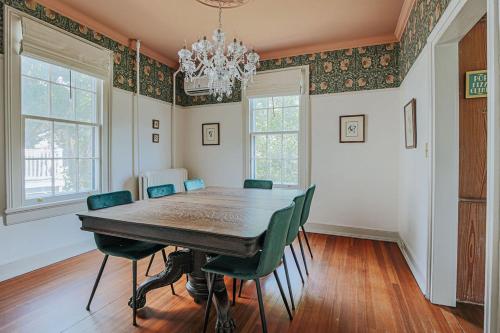 a dining room with a wooden table and green chairs at The Woodward in Staunton