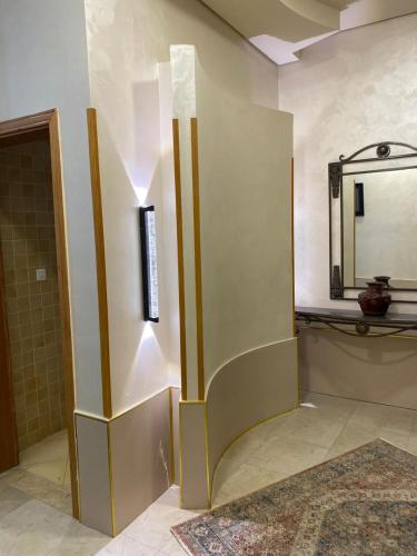 a bathroom with a wall with a mirror at Armada Avenue Hotel Amman in Amman