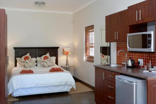 una piccola camera da letto con un letto e una cucina di Yellow Aloe a Clanwilliam