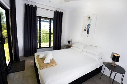 a bedroom with a large white bed and a window at Stonewood Views in Diwan