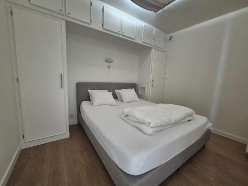 a white bedroom with a large bed with white cabinets at Sealview Nevada in Koksijde