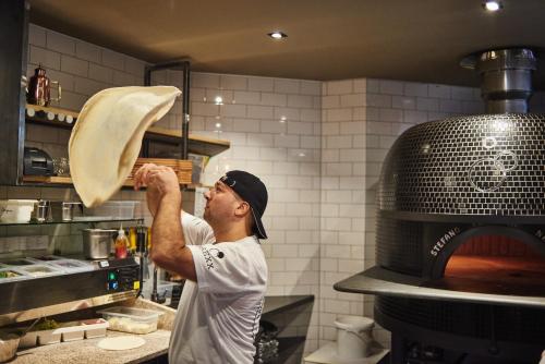 a man is standing in a kitchen preparing food at Hotel Zugbrücke Grenzau GmbH in Höhr-Grenzhausen