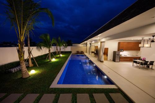 a swimming pool in the backyard of a house at night at Angkor Rendezvous in Siem Reap