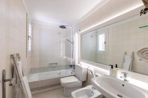 a bathroom with a toilet and a sink and a tub at Ancla 1 in Port d'Andratx