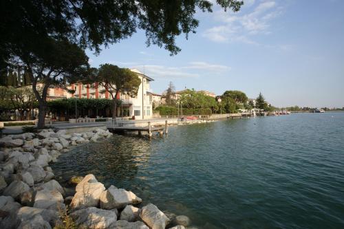 a view of a river with rocks and houses at Hotel Giardino in Sirmione