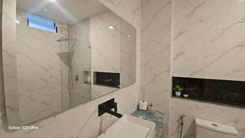 a bathroom with a toilet and a sink and a mirror at Beas Place Klong Dao in Ko Lanta