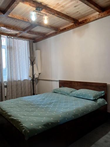 a bedroom with a bed with a wooden ceiling at Мурас хостел in Var-Kyshtak