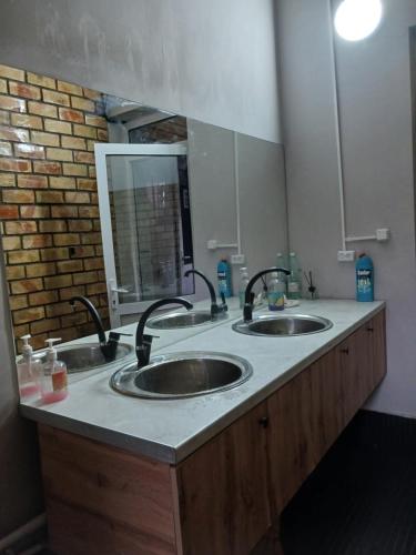 a bathroom with two sinks and a mirror at Мурас хостел in Var-Kyshtak