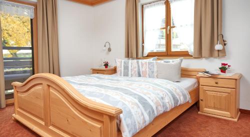 ein Schlafzimmer mit einem Holzbett und einem Fenster in der Unterkunft Haus Bergland in Fischen im Allgäu
