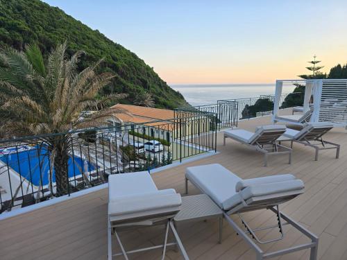 a balcony with chairs and a view of the ocean at Corfu valley view in Paleokastritsa