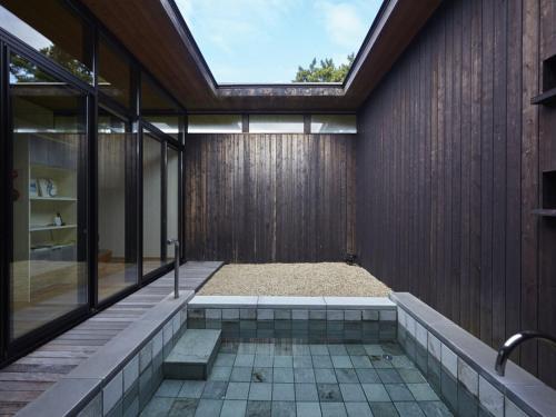 a house with a jacuzzi and a glass wall at Numazu Club in Numazu