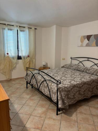 a bedroom with a bed and two windows at Casa Sant'Antonio in Orosei