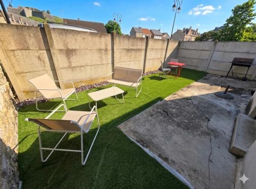 a group of chairs and tables in a yard at Studio Le Vale - Centre Ville de Givet in Givet