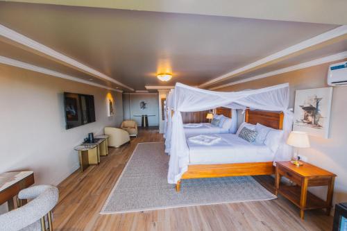 a bedroom with a bed with a canopy at Hemingway's Hotel in Entebbe