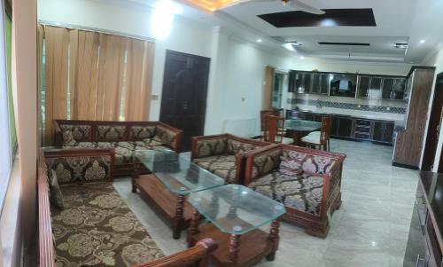 a living room with couches and a table and a kitchen at Koh E Sukoon Apartments in Patriata