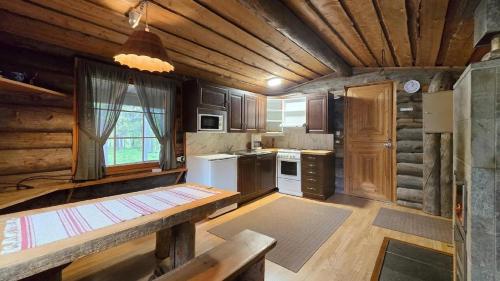 a kitchen with wooden cabinets and a table in a room at River cabin Tapio in Inari