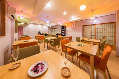 a restaurant with wooden tables and chairs at Hanaingen in Kusatsu