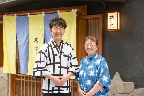 a man and a woman standing in front of a house at Hanaingen in Kusatsu