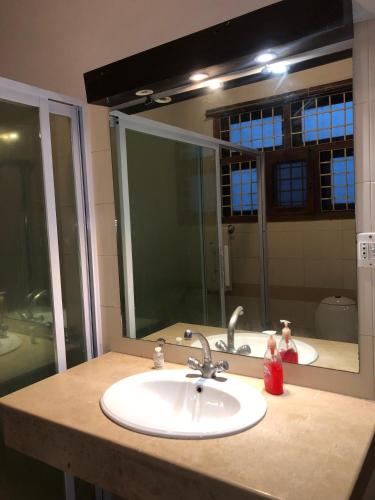 a bathroom with a sink and a large mirror at The Exclusive House in Peshawar