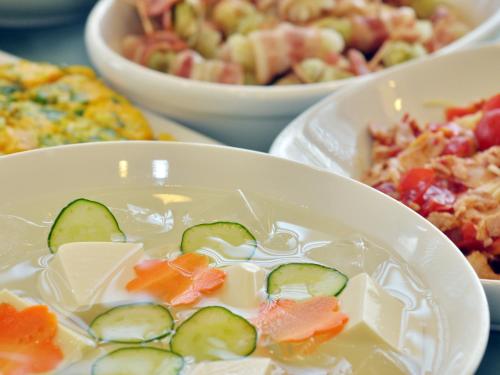 a white bowl of food with cucumbers and cheese at Hotel Green Arbor in Sendai