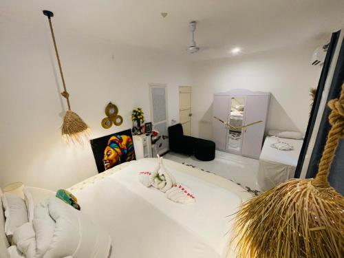 a white room with a white bed and a room with at Malaika white house in Kiwengwa