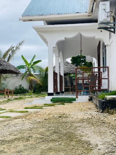 a white house with a table and chairs in it at Malaika white house in Kiwengwa