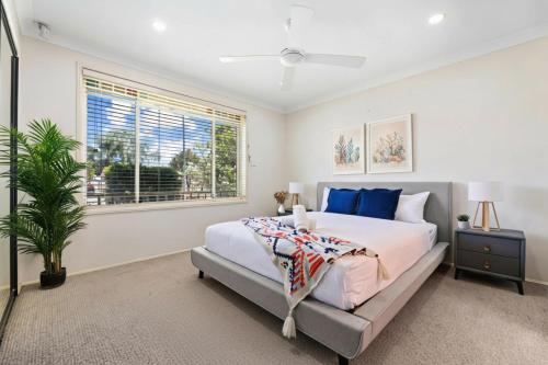a bedroom with a large bed and a window at Escape from Relaxing Poolside House 3B in Narellan